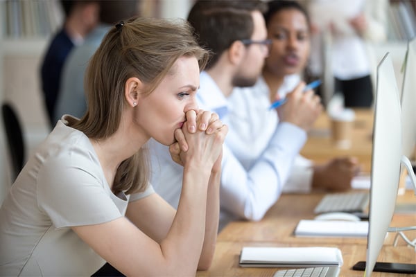 frustrated-female-at-crowded-office-looking-at-computer-screen