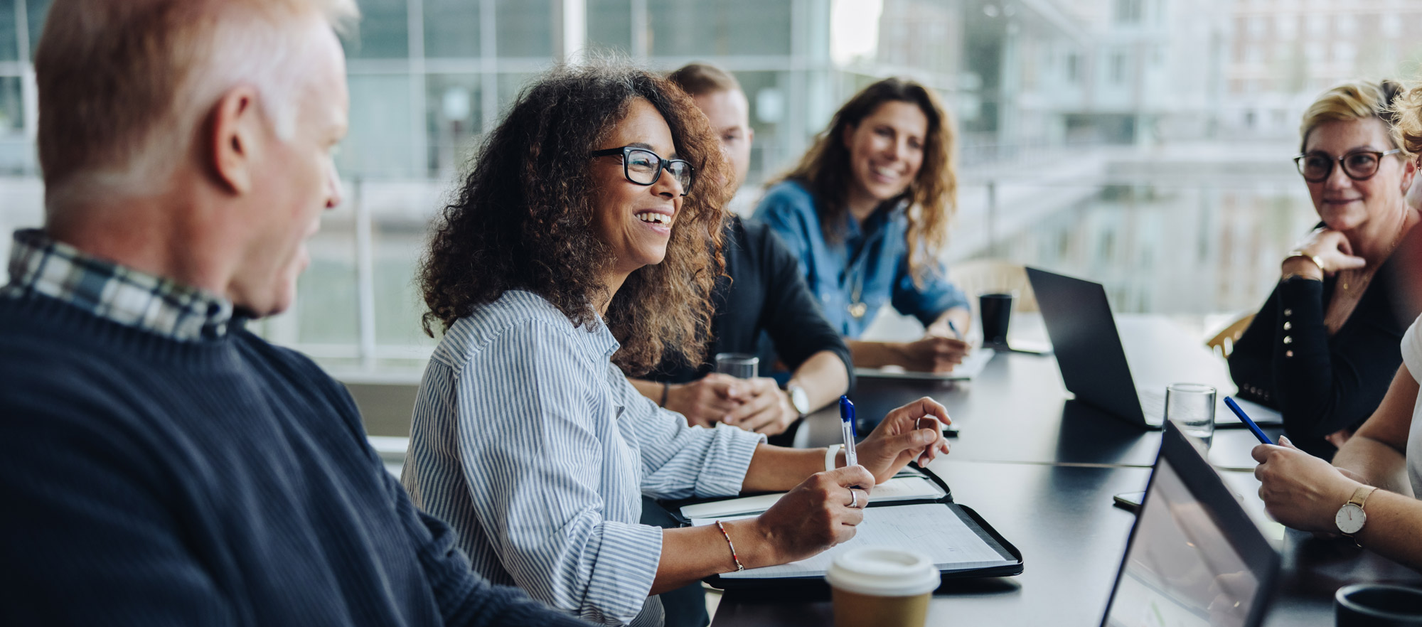 Colleagues smiling during meeting at table