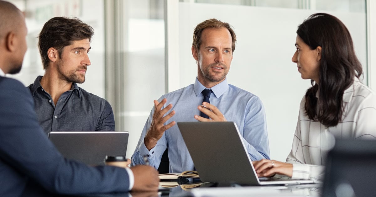 Four people in business meeting talking