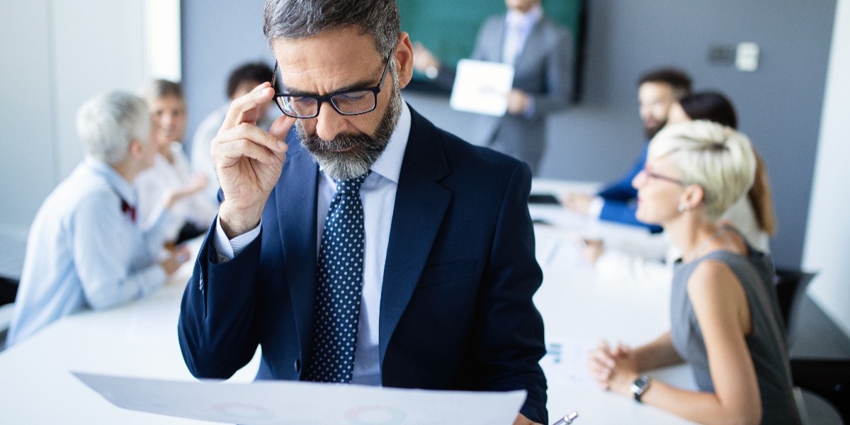 Concerned businessman looking at piece of paper